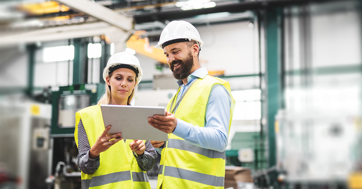 Chemical manufacturers reviewing compliance standards on a tablet